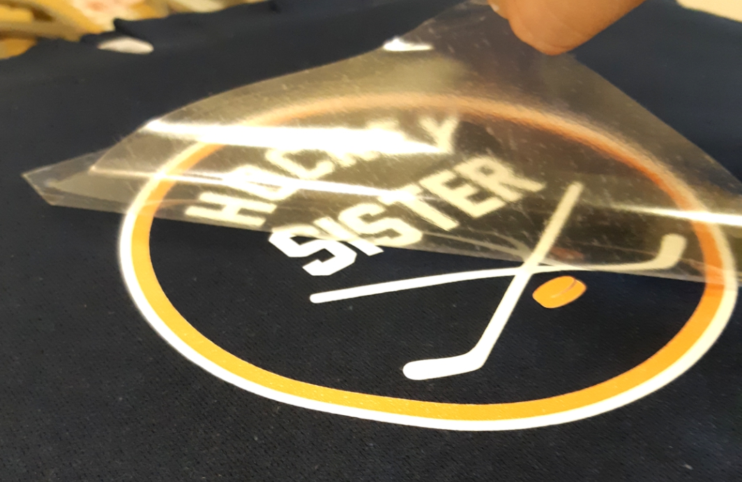 digital logo being heat applied to black t shirt